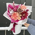 Букет Карнавальная Ночь из декоративного ананаса, цимбидиума, роз кахалы, илекса, ветки в снегу и декора