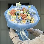 Букет Шум Моря из дельфиниума, эустомы, оксипеталума, роз сорта капучино, тринити