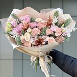 Букет Тепло зимних дней из нобилиса, кустовых роз, скиммии, диантусов, рускуса и декоративных ананасов