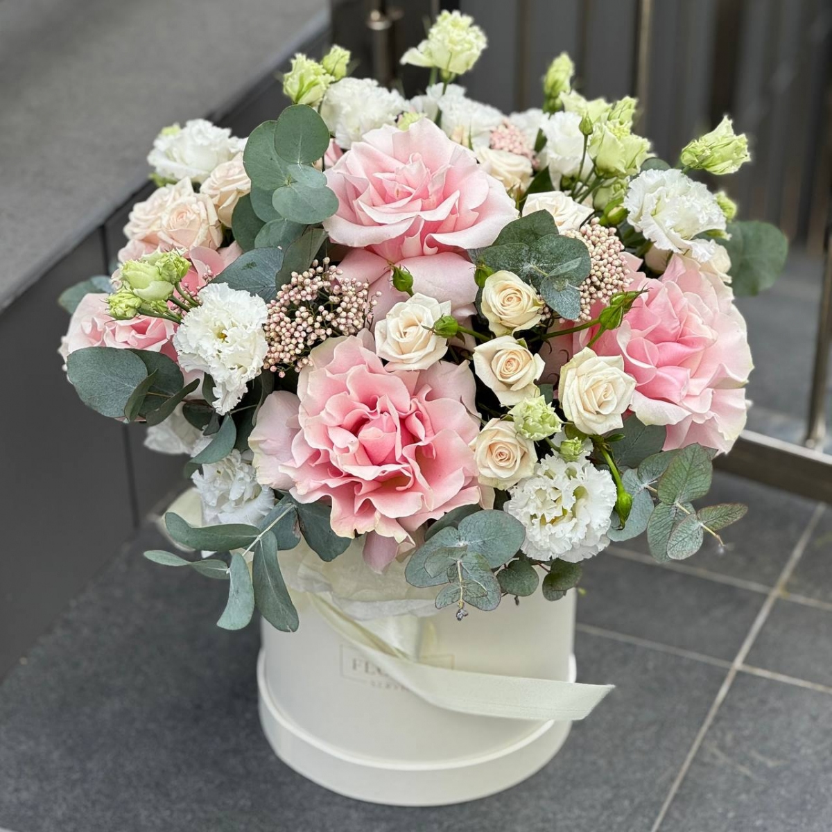 Композиция Нежный румянец из кустовых и одноголовых роз, эустомы, озотамнуса и эвкалипта