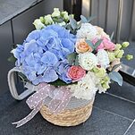 Композиция Аромат Счастья в плетеном кашпо с гортензией, эустомой, кустовыми розами и др.